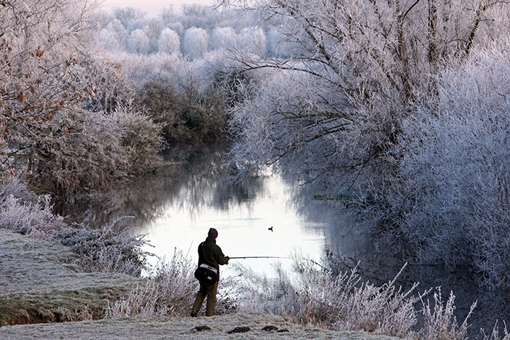 Cold snap continues: A fisherman tries his luck along the banks of the River Cam at Granchester