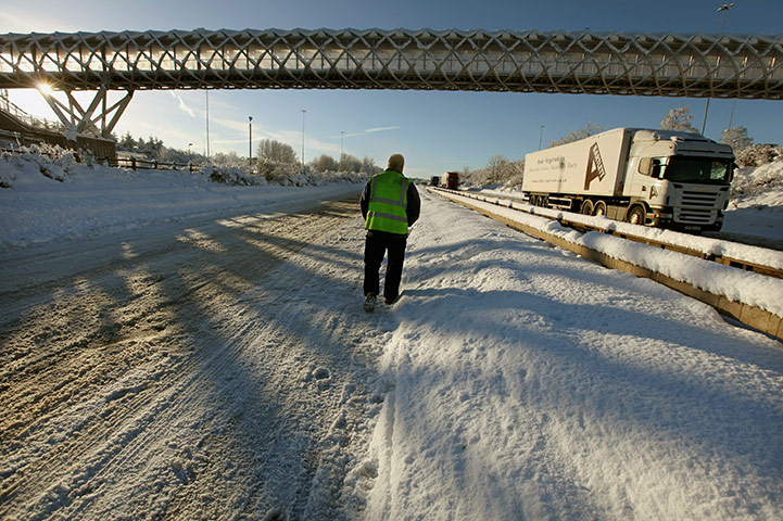 Freezing weather: A truck driver inspects the road surface on the M8 motorway