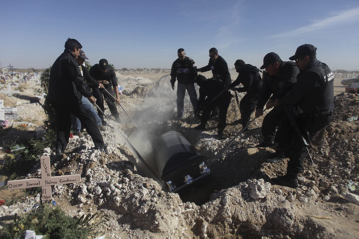 24 hours: Ciudad Juarez, Mexico: Relatives lower the coffin of slain police officer