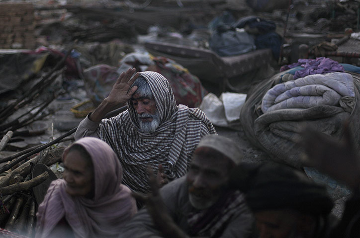 24 hours: Rawalpindi, Pakistan: An elderly Pakistani man tries to keep warm