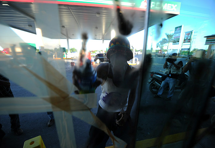 COP16 updates: An activist sprays the window of a fast food restaurant in Cancún