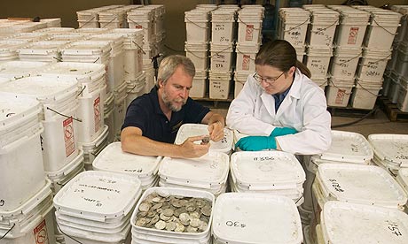 Odyssey staff examine coins recovered from the 'Black Swan' shipwreck