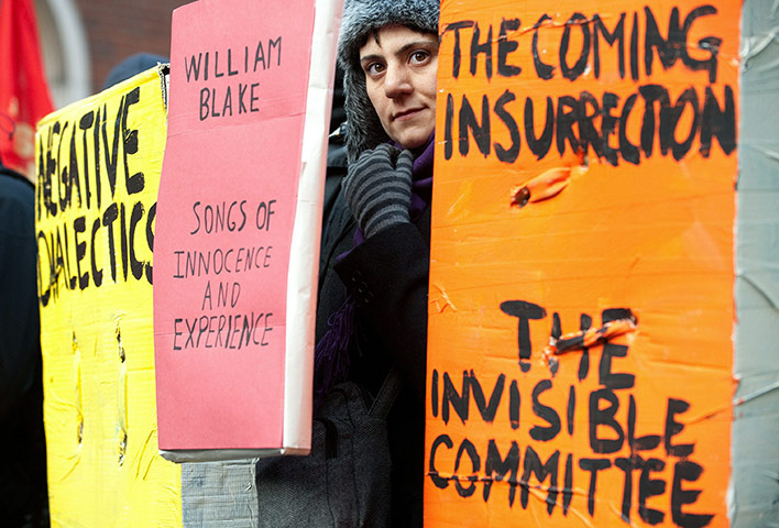 Student Protests : A demonstrator is pictured between giant textbooks during London protest