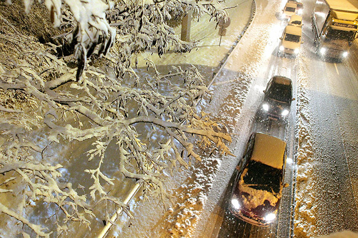 Cold weather abroad: Reims, France: Cars drive on a snow-covered road