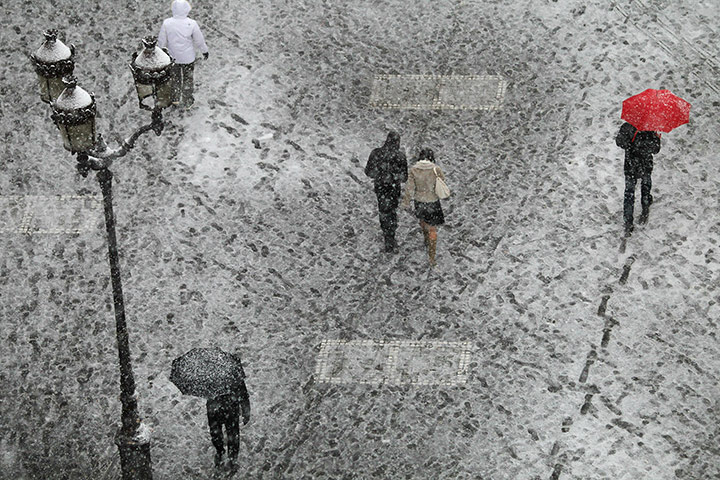 24 hours in pictures: People cross the snow-covered Bourse square in Paris