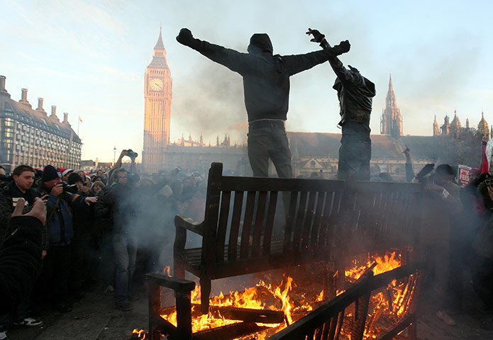 student protest update: Two demonstrators stand ontop of a bonfire in Parliament Square