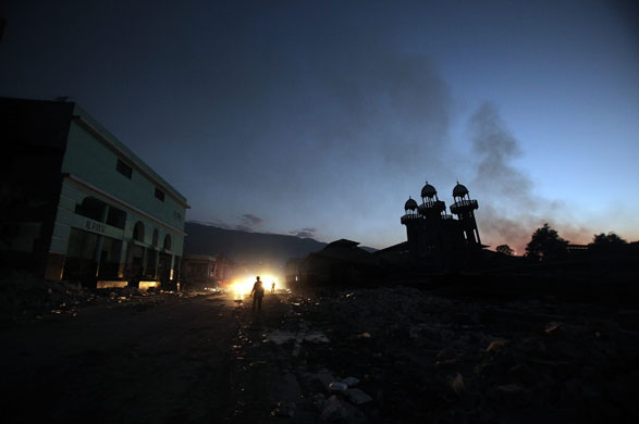 24 hours : Port-au-prince, Haiti : A fire burns behind a market as dusk falls