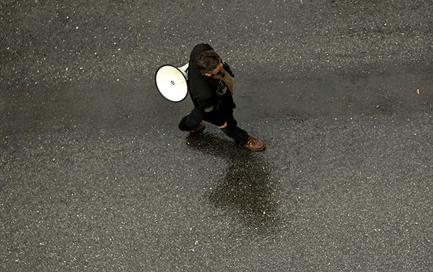 Greece strike: A lone protester carrying a loudspeaker 