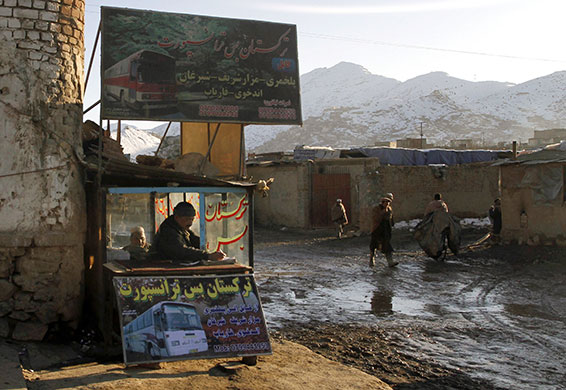24 hours: An Afghan man makes notes at a bus travel agency 