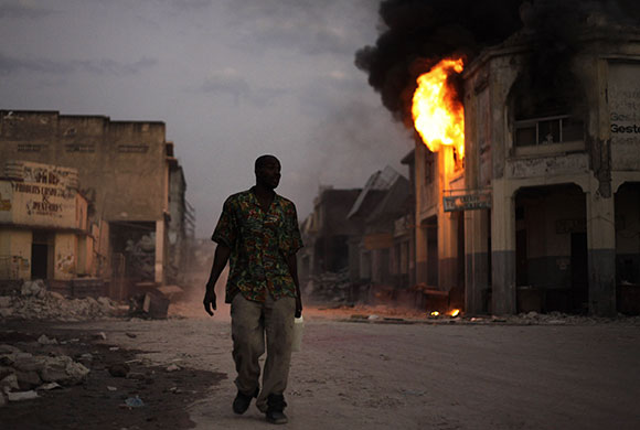 24 hours: A man walks near a fire in a book store in Port-au-Prince