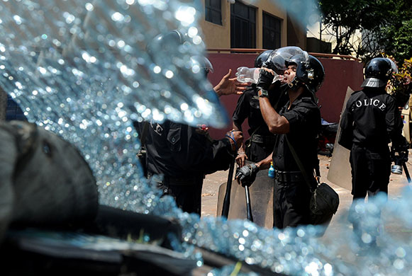 24 hours: A policeman, seen through the windscreen of a damaged car in Colombo