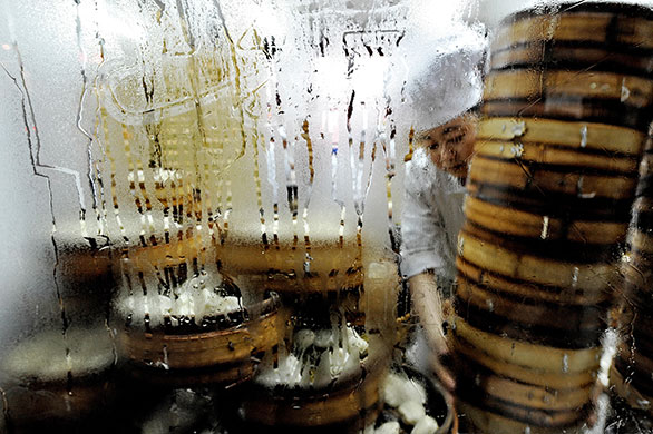 24 hours: A Chinese cook arranges baskets used to steam dumplings in Shanghai