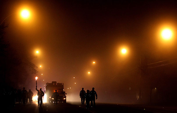 24 hours: Torchbearer Damon Jones carries the Olympic flame through heavy fog