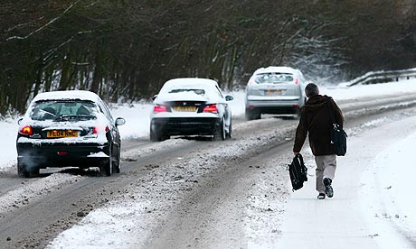 A man walks along the A28 in Ashford, Kent, after overnight snowfall
