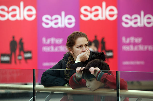 Week in Business: A woman and child take a break from sales shopping in Westfield 