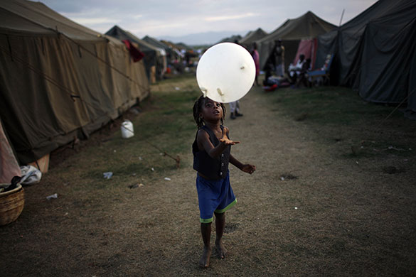 24 hours in pictures: Leogane, Haiti: A girl plays with a balloon in a refugee camp