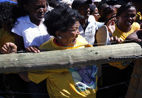 Mandela celebrations: A woman is pushed against a barbed wire fence