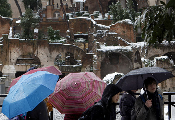 snow in Rome: Tourists look at snow-covered ruins