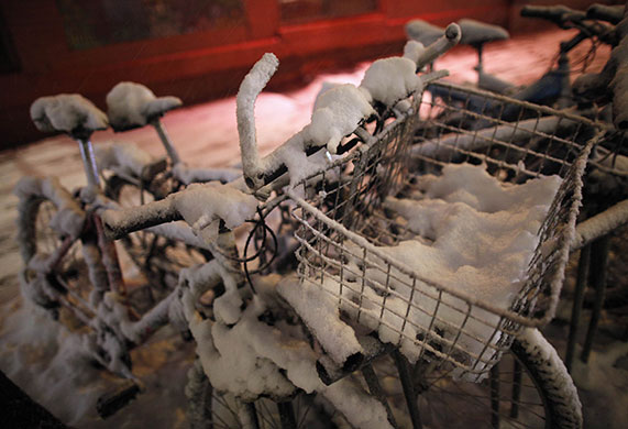 24 hours in pictures: New York, USA: Bicycles covered with snow are parked outside a restaurant