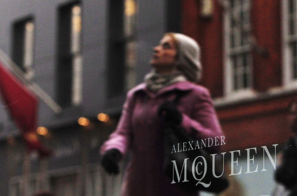 24 Hours in Pictures: A woman is reflected in the windows of Alexander McQueen's store in London