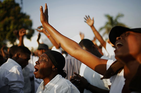 24 Hours in Pictures: People pray during a national day of mourning outside the national palace