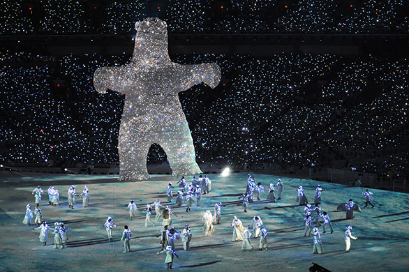winter olympics ceremony: Artists perform next to a 20-meter LED light covered spirit bear puppet 