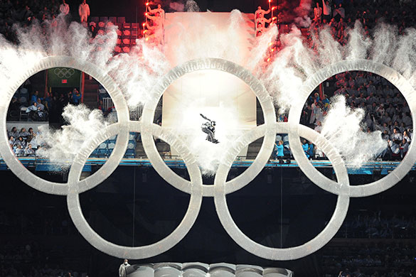 winter olympics ceremony: A snowboarder jumps through the Olympics rings during the opening ceremony 