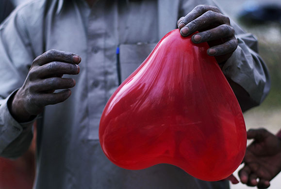 24 hours: Islamabad, Pakistan: A vendor prepares a balloon for Valentine's Day 