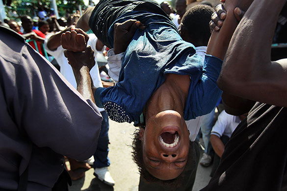 24 hours: Port-au-Prince, Haiti: Earthquake survivor is carried after breaking down