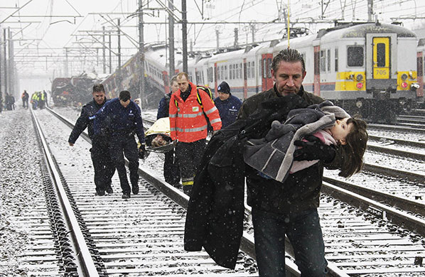 Train crash in Belgium: A man carries a child from the site where two trains crashed
