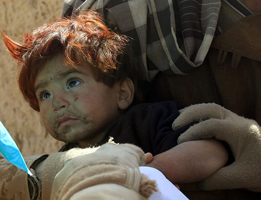 Operation Moshtarak: US Marine Gunnery Sergeant holds a toddler in the town of Marjah