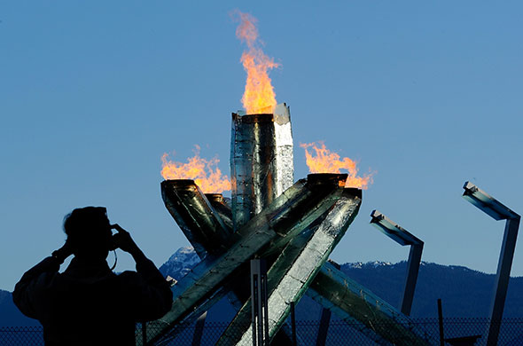 Winter Olympics day 6: Spectators take photos of the Olympic cauldron