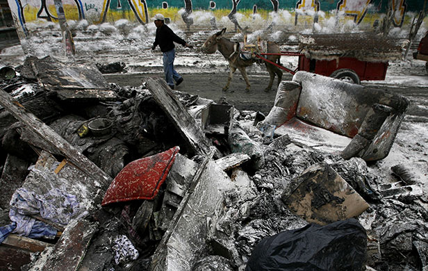 24 hours in pictures: Mexico City, Mexico: A resident uses a donkey and a cart to remove debris