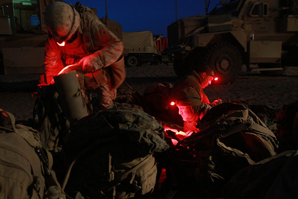 24 hours in pictures: Marjah, Afghanistan: US Marines read and pack their gear under red lights