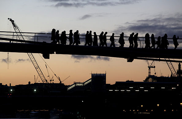 Week in business: Members of the public cross the Millennium footbridge as the sun in London.
