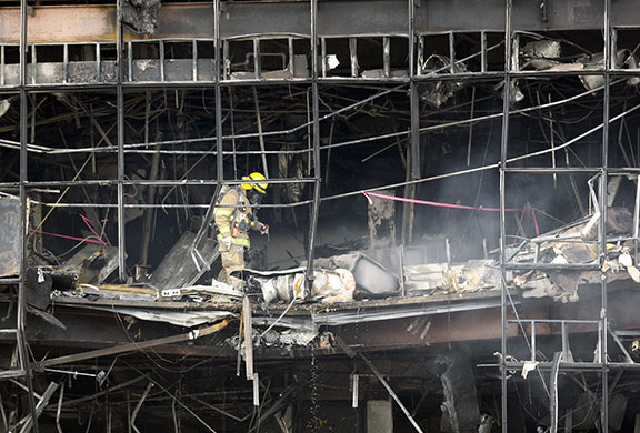 Austin plane crash: A firefighter walks inside a damaged building