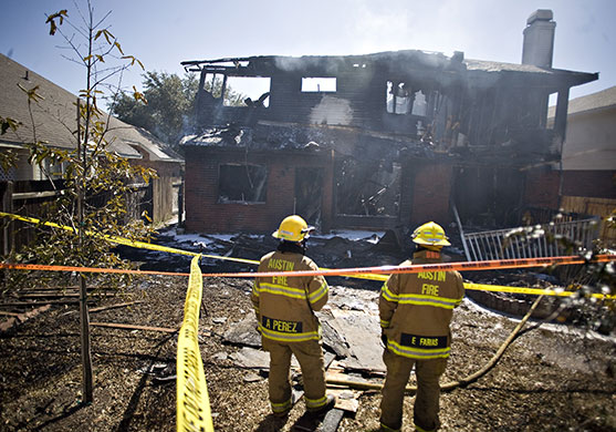 Austin plane crash: Two firemen are seen at the home belonging to Joseph Stack
