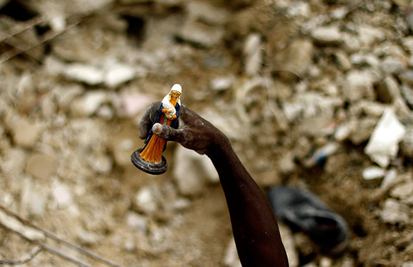 24 hours in pictures: man holds small statue of the Virgin Mary and Child Port-au-prince, Haiti 