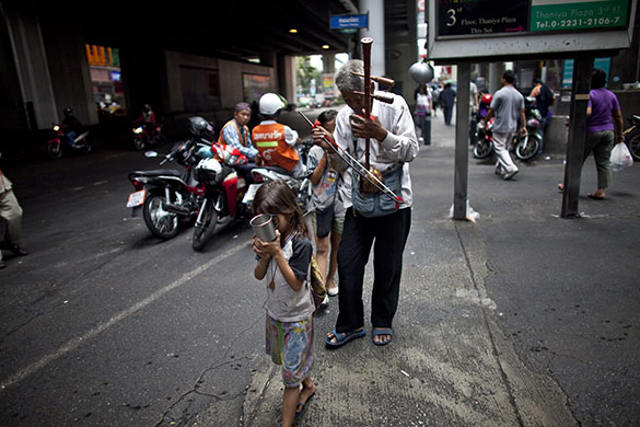 24 hours in pictures: Bangkok, Thailand: A blind beggar is led by children