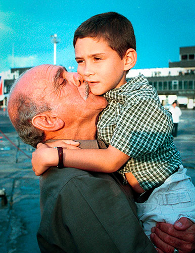 Elian Timeline: Elian Gonzalez is cradled by his grandfather after his arrival in Havana