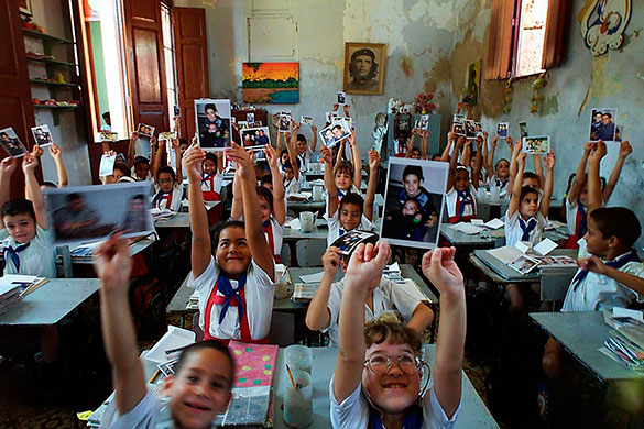 Elian Timeline: Young pupils at the school attended by Elian Gonzalez hold pictures of him