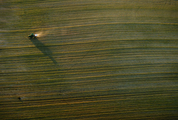 24 hours in pictures: Spain: A tractor travels in a field near Donana Natural Reserve