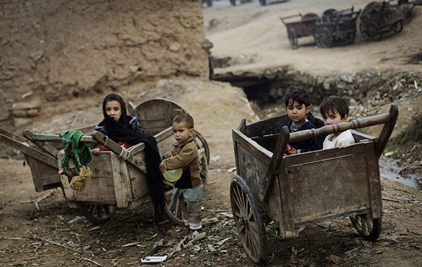 24 Hours in Pictures: Afghan refugee children hang out with wooden carts on the roadside