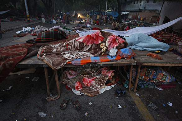 24 hours in pictures: New Delhi, India: A man sleeps on top of a temporary stage