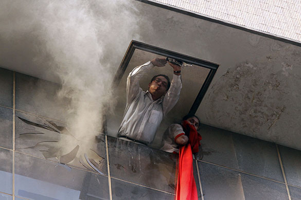 24 hours in pictures: Bangalore, India; People look through a window as they wait to be rescued
