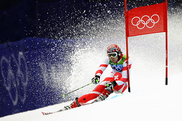 winter olympics day 12: Carlo Janka sweeps past a gate on his way to winning the gold