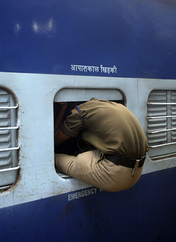 24 hours in pictures: Bhubaneswar, India: A security officer boards a train