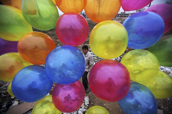 24 hours in pictures: Islamabad, Pakistan: Tanveer Mouneer sells balloons at a roadside