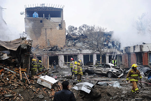 Kabul explosions: Afghan firemen gather to inspect the debris at the site of a blast