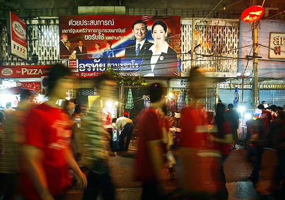 Thaksin Shinawatra: People walk past an election campaign bi